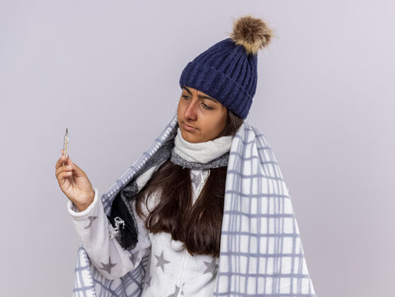 围巾想着那个戴着冬天帽子 披着方格围巾的生病的小女孩 手里拿着一支温度计 看着隔离在白色背景上的温度计格子布包裹女孩