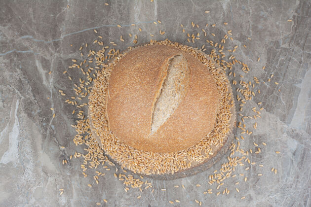 面包未煮的燕麦和面包放在大理石表面美味干的面包