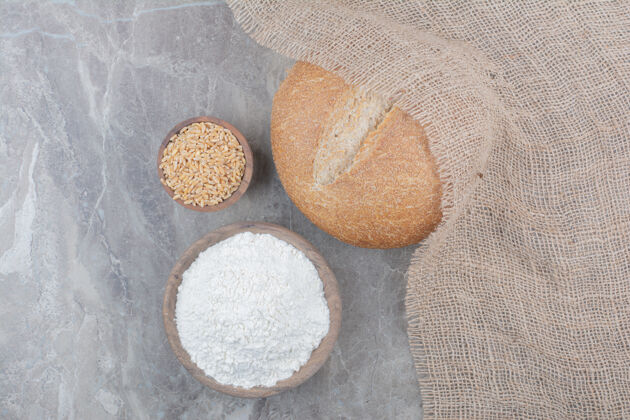 谷物一条白面包 在大理石表面涂上燕麦和面粉面粉食品面包