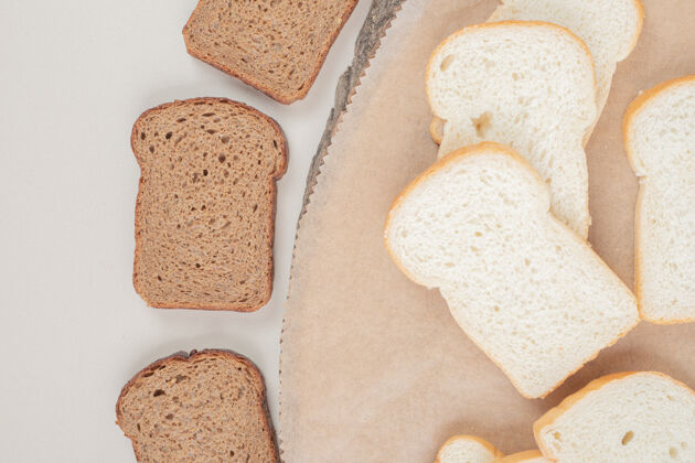 营养把新鲜的白棕色面包片放在木盘上切片面包房切