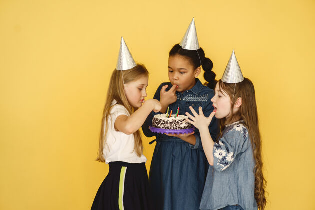 美国孩子们的生日被隔离在黄色的墙上孩子们拿着蛋糕美丽小孩子