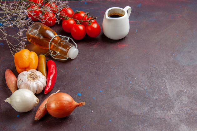 素食者在深色的桌子上可以看到新鲜的蔬菜和橄榄油油西红柿蔬菜