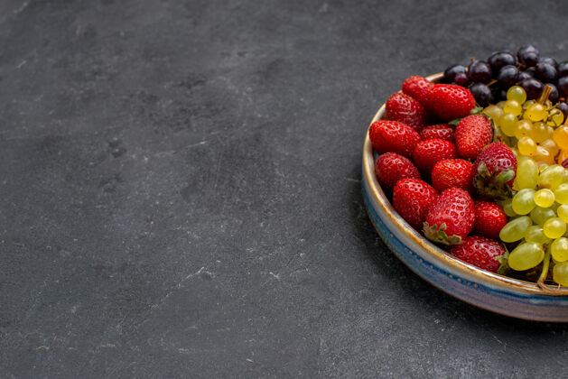 成分前视图水果成分草莓葡萄覆盆子和橘子在黑暗的空间健康水果生的