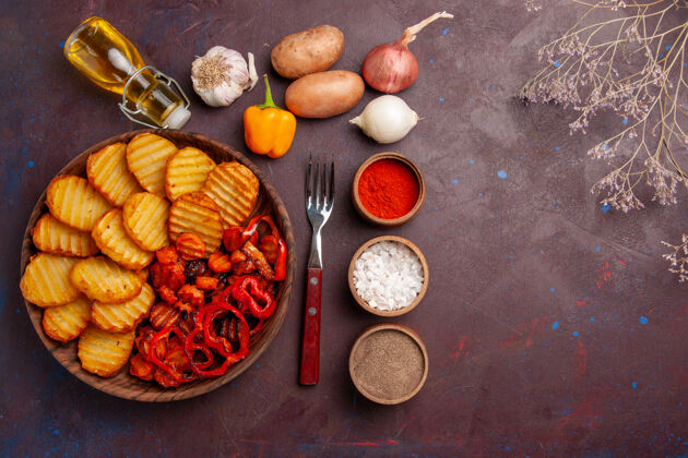 可食用水果在黑暗的桌子上俯瞰不同调味料的烤土豆烘焙顶部土豆