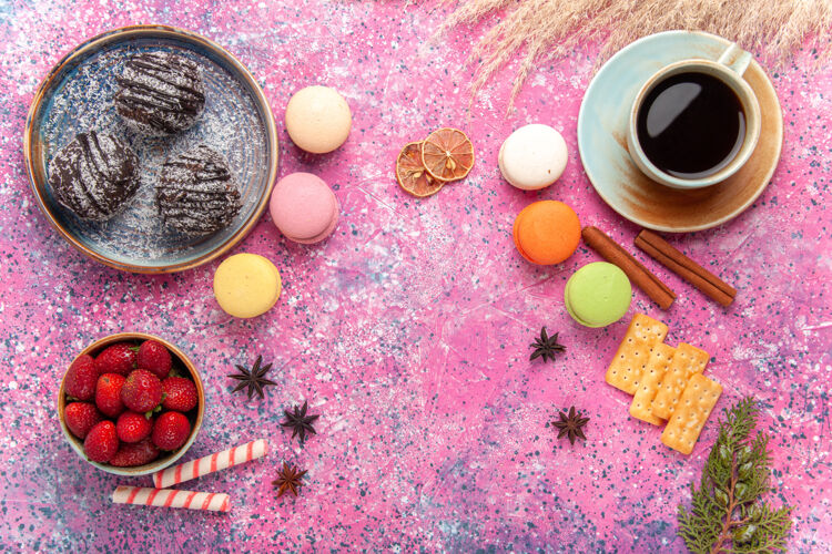 杏仁饼顶视图美味的巧克力蛋糕与法国马卡龙在粉红色饼干食物水果