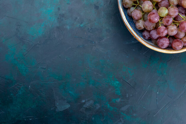 水果顶视图新鲜葡萄多汁水果深色办公桌水果盘子食物紫色