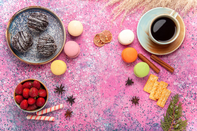 杏仁饼顶视图美味的巧克力蛋糕与法国马卡龙在粉红色饼干食物水果