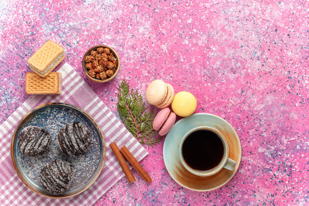 杯子顶视图美味的巧克力蛋糕与茶和麦卡龙粉红茶饼干派