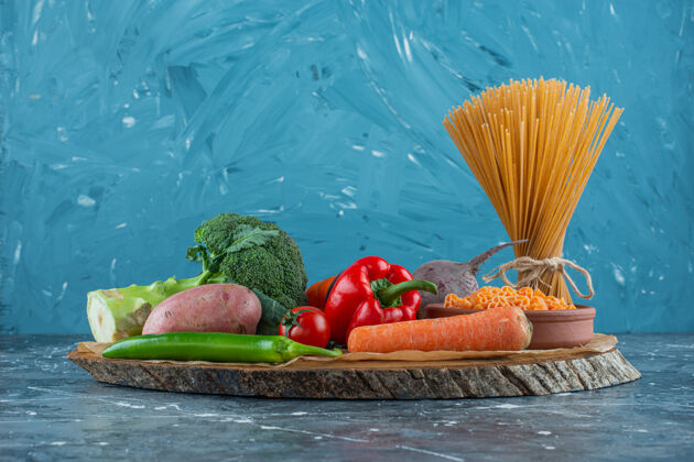 营养在大理石背景上 将蔬菜放在意大利面旁边的木板上甜椒蔬菜生的