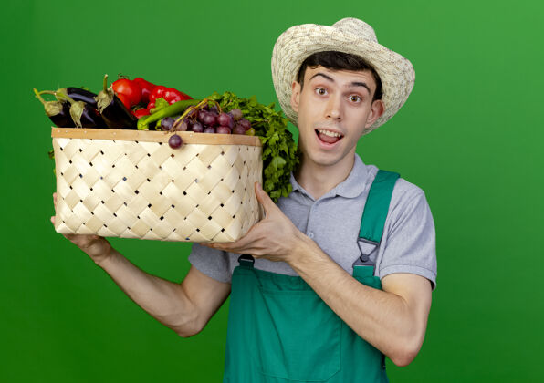 空间惊讶的年轻男园丁戴着园艺帽拿着菜篮花园男性园艺