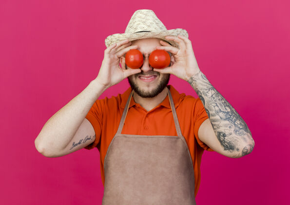 番茄戴着园艺帽的未被雇佣的男园丁拿着西红柿闭上眼睛空间眼睛园艺