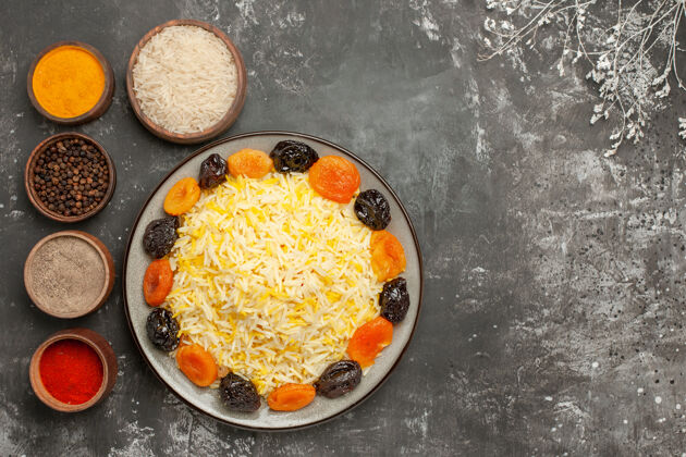 胡椒顶视图米饭和干果在盘子旁边的一碗香料树树枝上树枝午餐肉