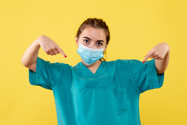 黄色前视图穿着医用衬衫和面罩的女医生 健康大流行病毒covid-19制服冠状病毒肖像医学女医生