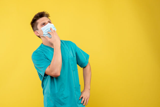 病毒黄墙上的男医生穿着医疗服 戴着无菌口罩套装面具人