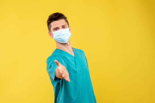 人黄色墙壁上 男医生穿着医疗服 带着无菌口罩问候绝育人疾病
