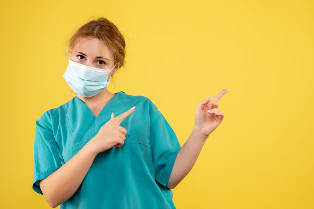 人黄墙上年轻女医生穿着医疗服 戴着口罩的正面图医院面具正面