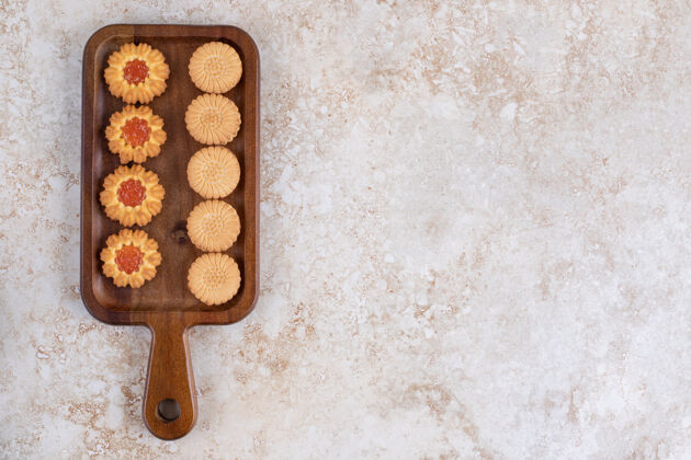 甜点石头桌上的一块木头板 上面放着甜饼 上面有小孔食品洞面包房