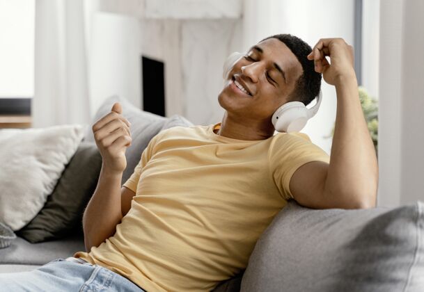 休闲肖像男在家放松 一边听音乐耳机设备房子