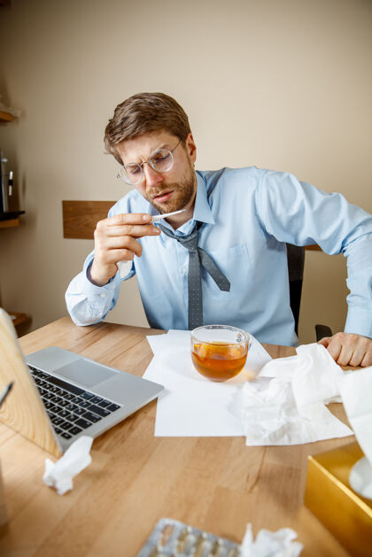 办公桌感到恶心和疲倦在办公室工作的人喝一杯热茶 商人感冒 季节性流感大流行性流感 疾病预防 办公室空调引起疾病医疗紧抓商务人员