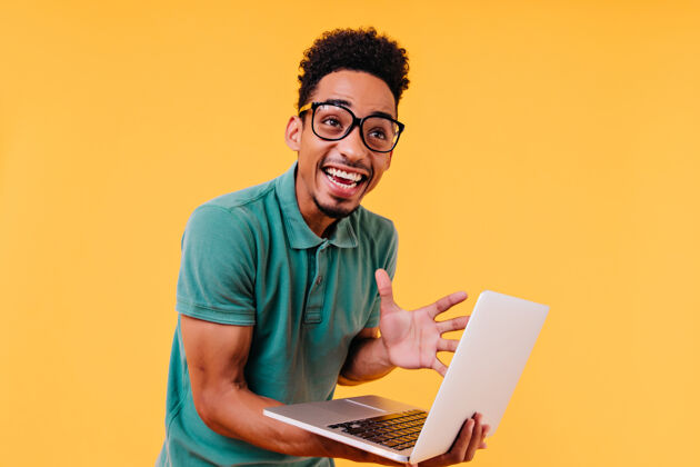 人戴着眼镜的黑人笑着表示兴奋情绪激动的国际学生拿着电脑非洲男人非洲