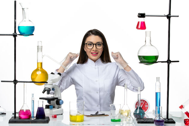 大流行前视图穿着白色医疗服的女化学家正坐在白色背景的科学冠状病毒-实验室大流行病毒的解决方案实验室坐着西装