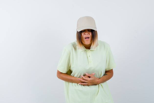 人穿着t恤 戴着帽子的年轻女士胃痛难忍 看起来很不舒服 正前方视图健康自然胃