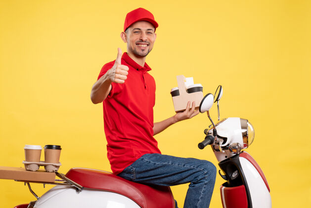 黄色正面图身着红色制服的男性快递员 穿着黄色服务颜色制服的咖啡 骑着送货员自行车人红色前面