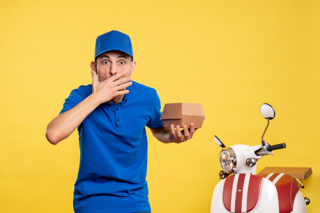 送货正面图：男快递员拿着黄色的小食品包 工作服 工作服 自行车工专业包装高尔夫