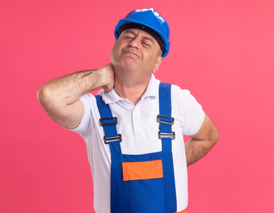 成年人疼痛的成年白人建筑工人穿着制服 脖子和背部都贴着粉红色的衣服背疼制服