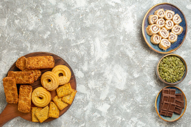 时钟在白色背景上俯瞰美味的蛋糕和糖果和饼干古董饼干金属