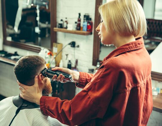 发型师客户在理发店剃须女理发师在沙龙性别平等女性在男性职业清洁沙龙胡子