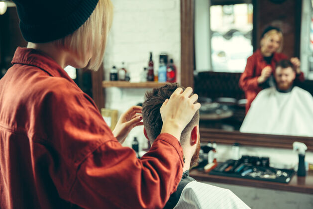 清洁客户在理发店剃须女理发师在沙龙性别平等女性在男性职业发型师女性客户
