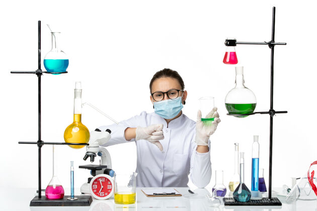 化学前视图穿着医疗服的女化学家 带面罩 背景为浅白色 飞溅实验室病毒化学covid-视图专业实验室