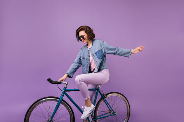 自行车微笑迷人的女孩坐在蓝色的自行车上幽默的女模特快乐自行车手美丽