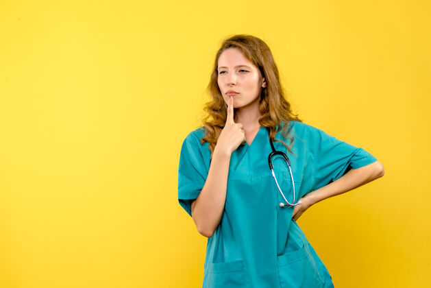 女士女医生在黄墙上思考的正面图医学医院保健