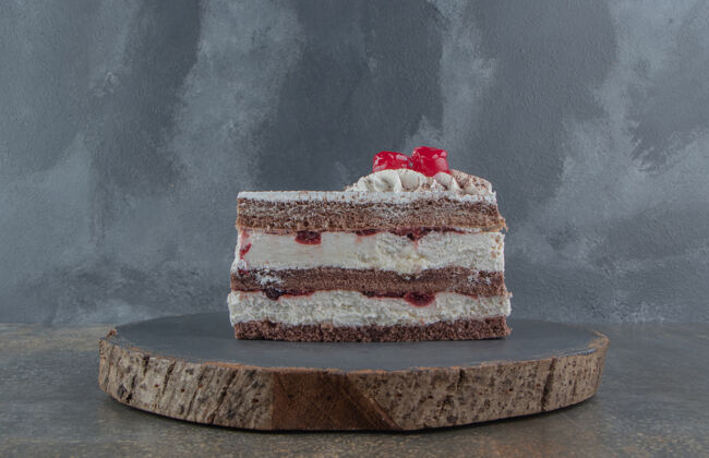 美味奶油樱桃蛋糕片放在一块板上糕点可口切片