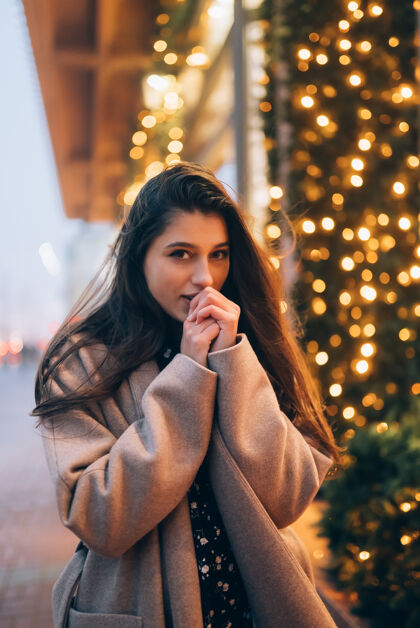 外套寒假季节圣诞节 新年概念城市街道上的女人灯饰橱窗年轻展示奇迹