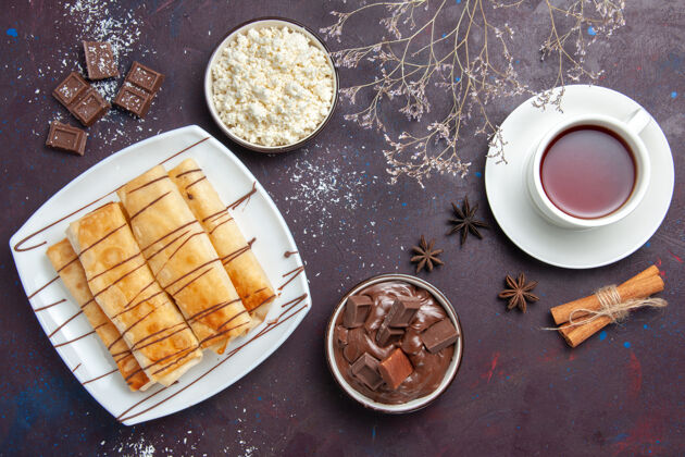 食物在黑暗的桌子上俯瞰美味的巧克力甜点和一杯茶茶营养素烘焙