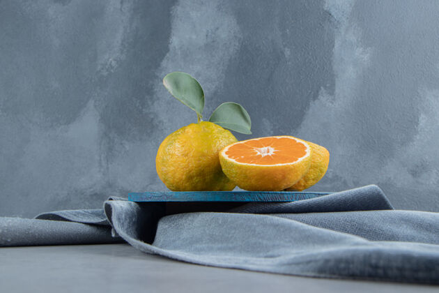 饮食橘子在蓝色的木板上 在一块布上 在大理石上营养水果风味