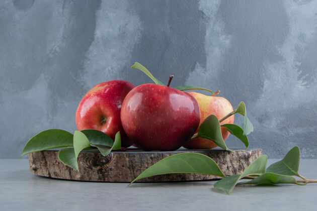 营养苹果和树叶捆在大理石木板上风味新鲜饮食
