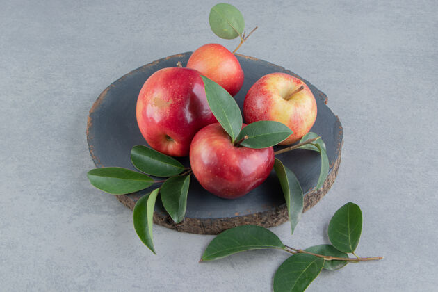 有机苹果和树叶捆在大理石木板上新鲜风味配料