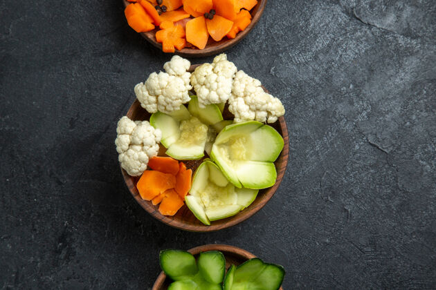 黄瓜顶视图不同设计的蔬菜在灰色桌子上的罐子里健康不同设计