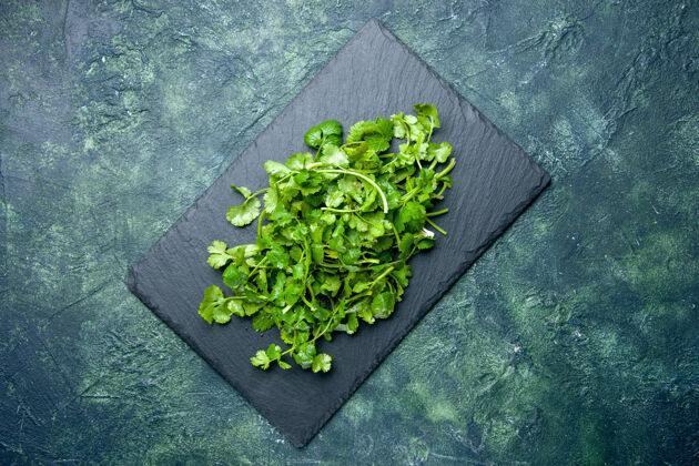 香草木砧板上的胡荽束俯视图 绿-黑混合色背景 自由空间蔬菜健康切