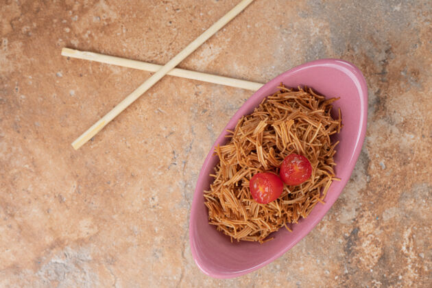 美味用筷子在粉红色的碗里炸西红柿粉丝高质量的照片切片面食筷子