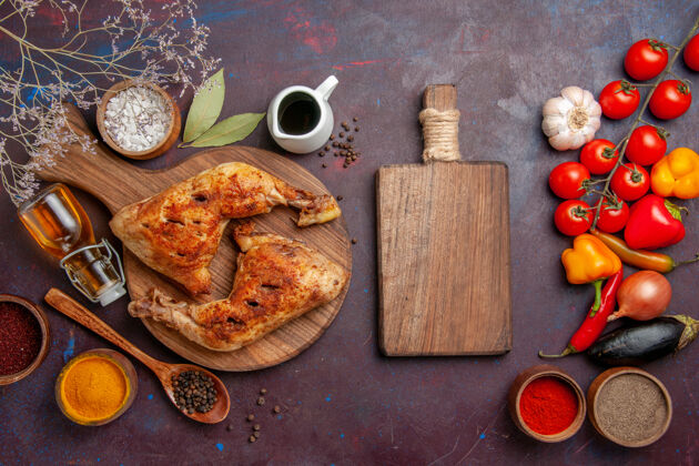 调味品俯瞰美味的炸鸡与调味品和蔬菜在黑暗的空间盘子晚餐菜肴