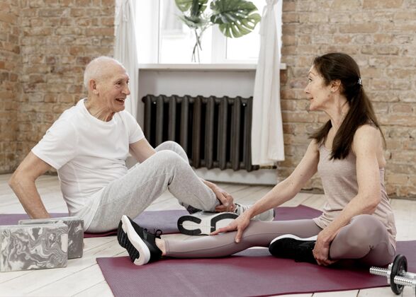 活跃全拍的人都在瑜伽垫上运动老年人女人