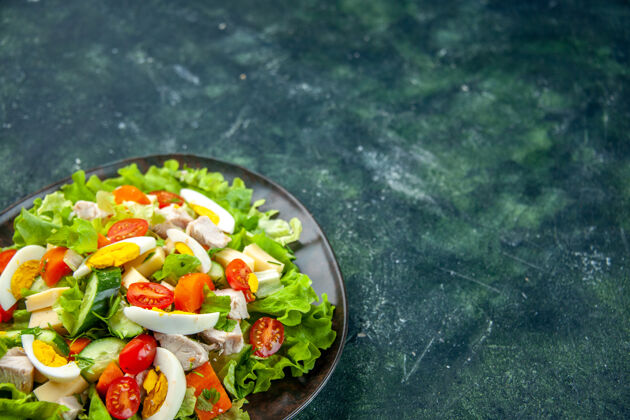 美味沙拉自制美味沙拉的正面图 在一个盘子里有许多配料 在黑绿色混合色背景上 有自由空间午餐权利前面