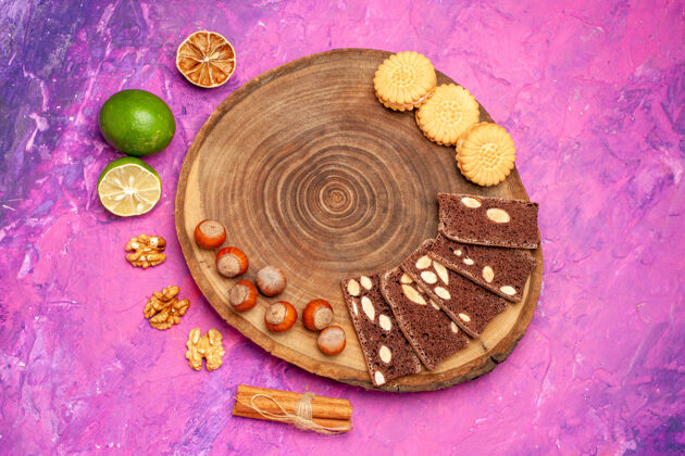 珠宝新鲜榛子的顶视图 粉色表面有饼干和蛋糕食品蛋糕饼干