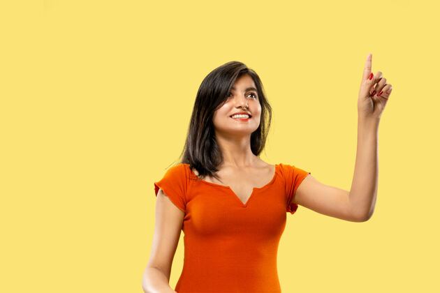 乐趣美丽的女性半身肖像隔离在黄色的工作室背景上年轻感性的印度女人穿着衣服指着和展示消极的空间面部表情 人类情感的概念女孩情绪女性
