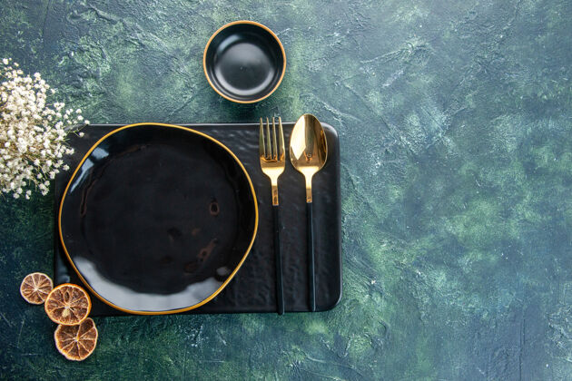餐厅顶视图黑色盘子 深色背景上有金色餐具 餐色晚餐银色餐厅服务餐具食物视图顶部光学仪器